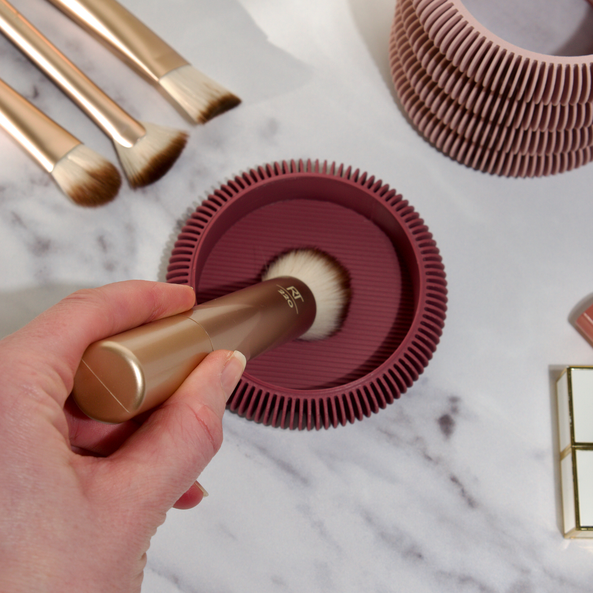 Deep cleaning a makeup brush using the 2-in-1 makeup brush cleaning tool. Textured surface helps deep clean brushes.