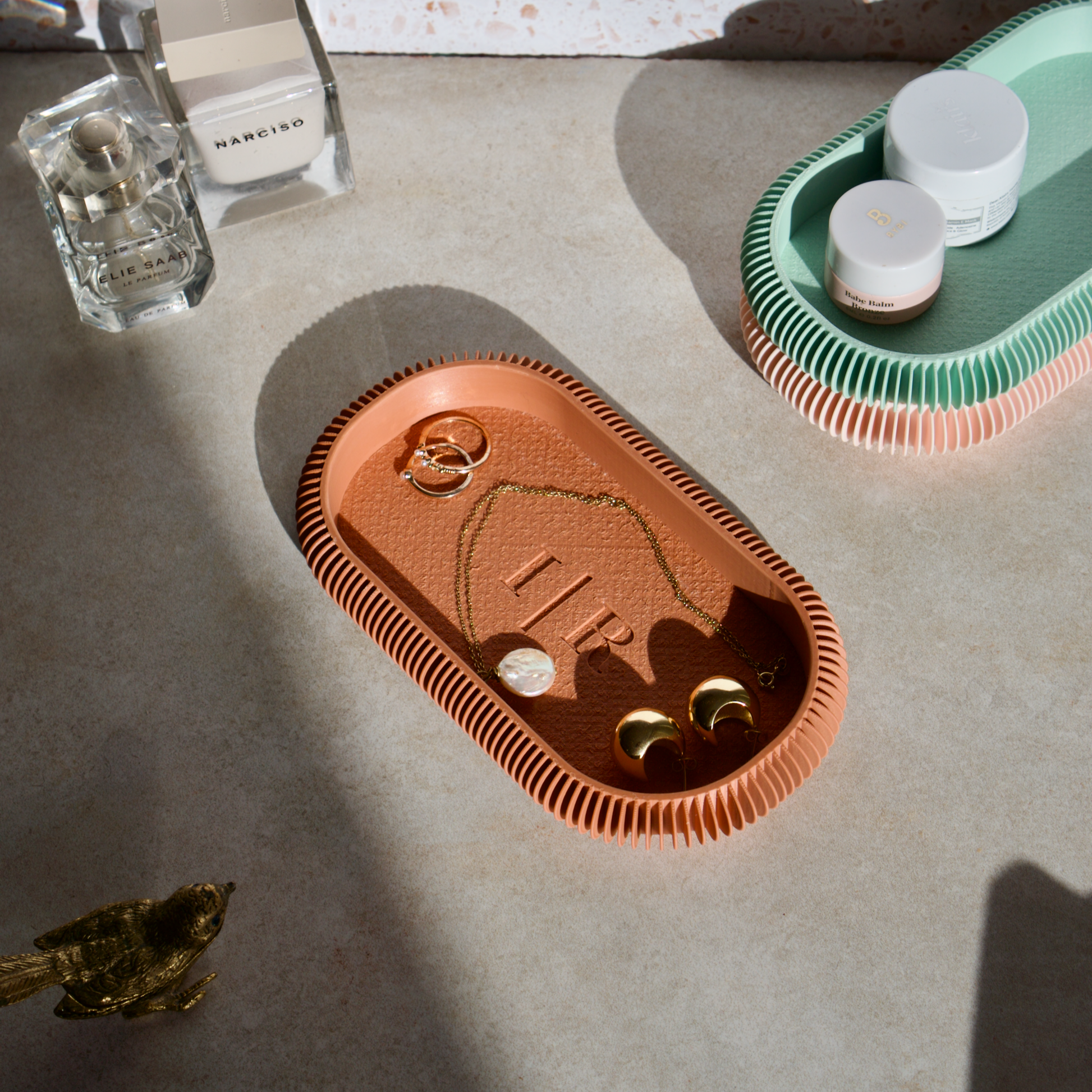 an oval trinket tray for organising jewellery. Light terracotta in colour and personalised with the initials I R.
